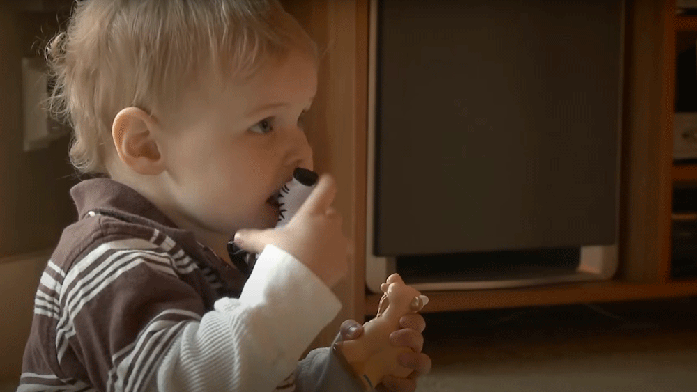 Young child putting toys in the mouth