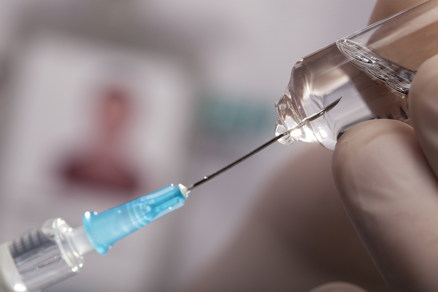 Image of a needle drawing up a vaccine