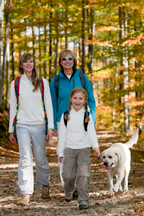A picture of a family hiking wearing long sleeved light coloured clothes to protect against insect bites.