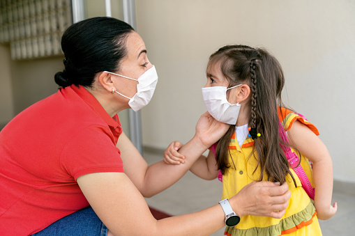 parent responding to child face to face with masks on