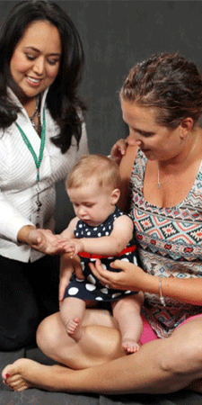 Mother holding baby with nurse