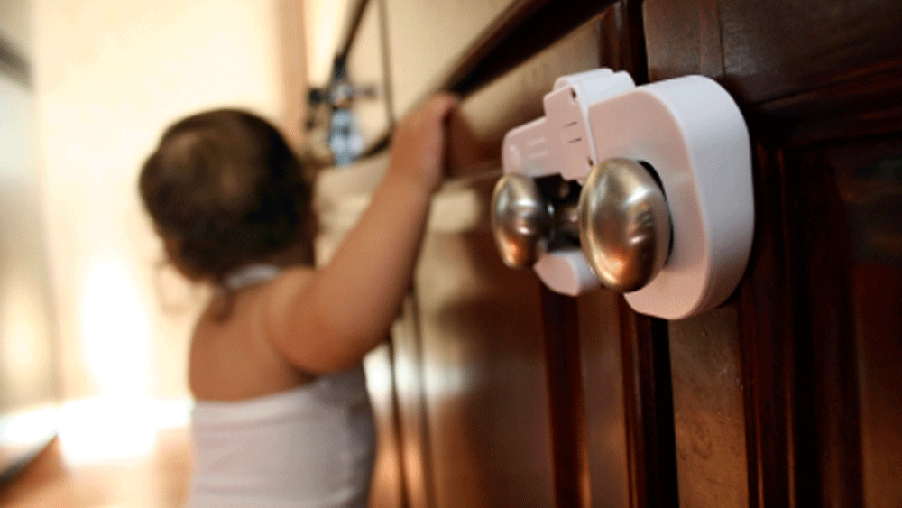 Child holding onto dresser