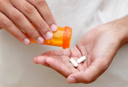 Dumping pills from bottle into hand