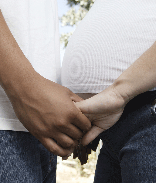 Pregnant couple holding hands