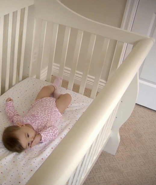 image of child in crib with no bumper pads