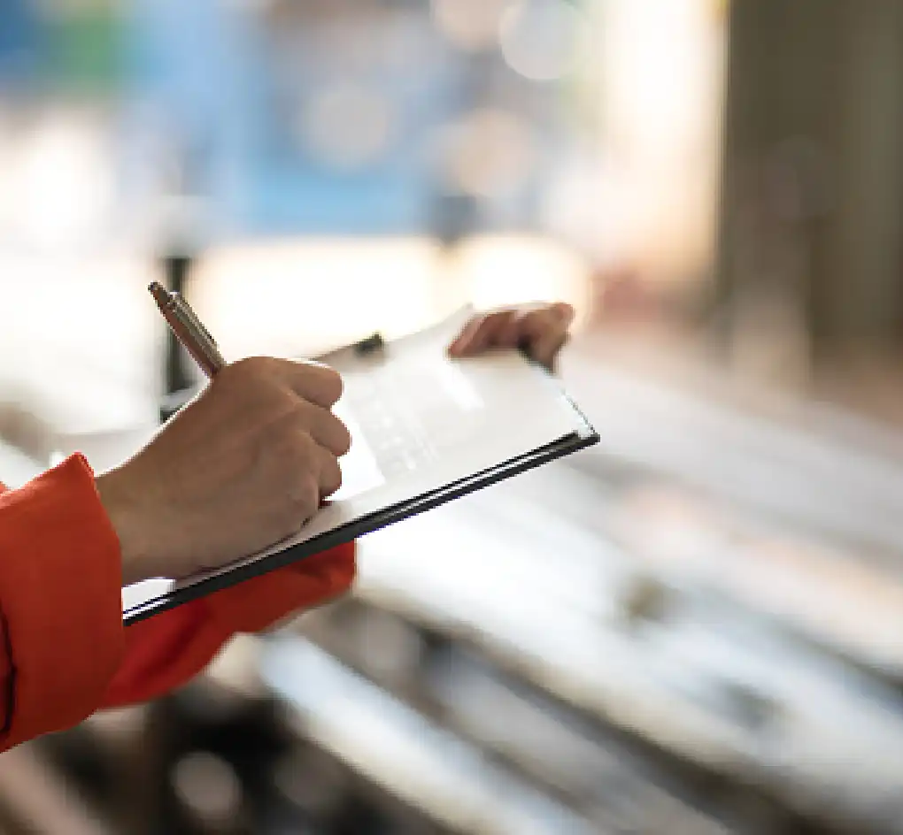 person filling out report or documents in paper format