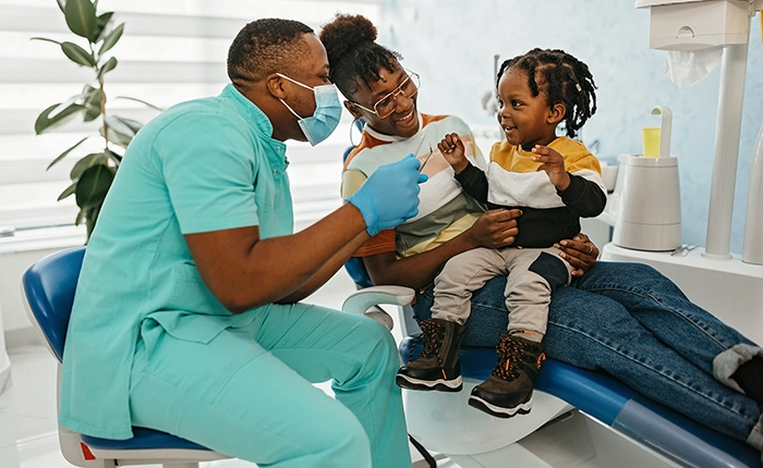healthcare provider helping a toddler in a dental clinic